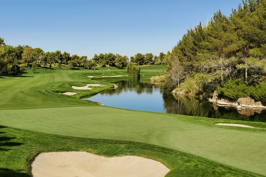 beautiful golf course with a pond and lush greenery